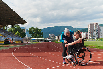 Image showing A woman with disability in a wheelchair talking with friend after training on the marathon course