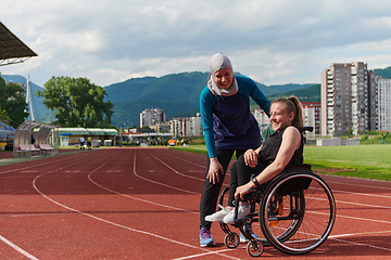 Image showing A woman with disability in a wheelchair talking with friend after training on the marathon course