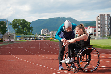 Image showing A woman with disability in a wheelchair talking with friend after training on the marathon course