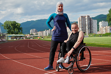 Image showing A Muslim woman wearing a burqa resting with a woman with disability after a hard training session on the marathon course