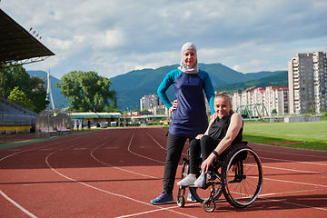 Image showing A Muslim woman wearing a burqa resting with a woman with disability after a hard training session on the marathon course