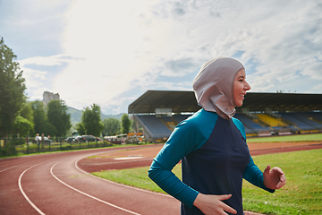 Image showing A muslim woman in a burqa sports muslim clothes running on a marathon course and preparing for upcoming competitions