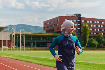 Image showing A muslim woman in a burqa sports muslim clothes running on a marathon course and preparing for upcoming competitions