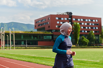 Image showing A muslim woman in a burqa sports muslim clothes running on a marathon course and preparing for upcoming competitions