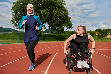 Image showing A Muslim woman in a burqa running together with a woman in a wheelchair on the marathon course, preparing for future competitions.