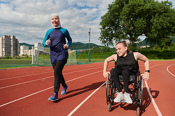 Image showing A Muslim woman in a burqa running together with a woman in a wheelchair on the marathon course, preparing for future competitions.