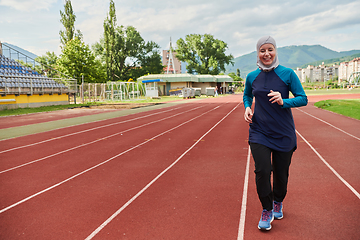 Image showing A muslim woman in a burqa sports muslim clothes running on a marathon course and preparing for upcoming competitions