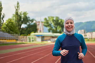 Image showing A muslim woman in a burqa sports muslim clothes running on a marathon course and preparing for upcoming competitions