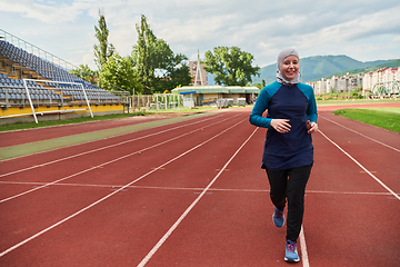 Image showing A muslim woman in a burqa sports muslim clothes running on a marathon course and preparing for upcoming competitions