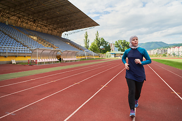 Image showing A muslim woman in a burqa sports muslim clothes running on a marathon course and preparing for upcoming competitions