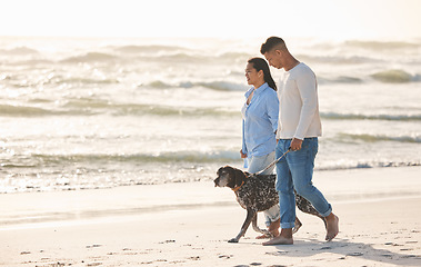 Image showing Beach, pet and couple walking with dog by ocean for freedom, adventure and bonding together in nature. Healthy animal, dating and man and woman by sea for exercise, wellness and training at sunset