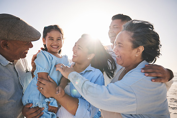 Image showing Family, smile and a girl on the beach with her grandparents in summer for holiday or vacation together. Love, sunset or flare with parents, kids and senior people by the ocean or sea for bonding