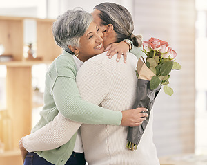 Image showing Mature couple, flowers and hug at home for anniversary, birthday or valentines celebration. Surprise, love and roses or bouquet with a man and woman for healthy marriage, happiness and romance