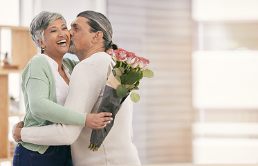 Image showing Mature couple, flowers and kiss at home for anniversary, birthday or valentines celebration. Surprise, love and roses bouquet with a man and woman for healthy marriage, happiness and mockup space