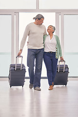 Image showing Mature couple, suitcase and walking in airport lobby, happy and travel together on tourist holiday. Man, woman smile and luggage for flight on vacation, immigration journey and global airplane trip