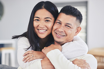 Image showing Love, hug and portrait of a couple in the living room bonding together in their modern house. Happy, smile and face of young man and woman with affection while relaxing in the lounge at home.