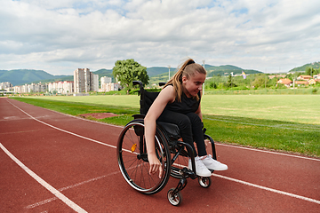 Image showing A woman with disablity driving a wheelchair on a track while preparing for the Paralympic Games