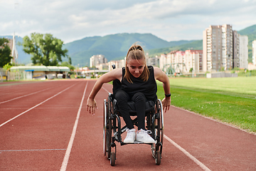 Image showing A woman with disablity driving a wheelchair on a track while preparing for the Paralympic Games