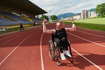 Image showing A woman with disability in a wheelchair showing dedication and strength by showing her muscles