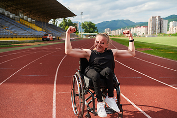 Image showing A woman with disability in a wheelchair showing dedication and strength by showing her muscles