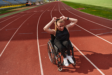 Image showing A woman with disability in a wheelchair showing dedication and strength by showing her muscles