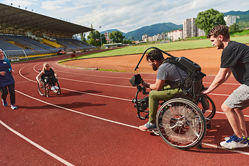 Image showing A cameraman filming the participants of the Paralympic race on the marathon course