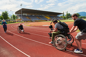 Image showing A cameraman filming the participants of the Paralympic race on the marathon course