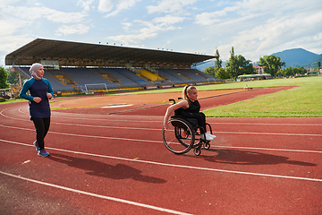 Image showing A Muslim woman in a burqa running together with a woman in a wheelchair on the marathon course, preparing for future competitions.