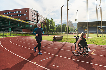 Image showing A Muslim woman in a burqa running together with a woman in a wheelchair on the marathon course, preparing for future competitions.