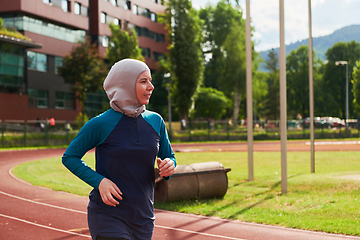 Image showing A muslim woman in a burqa sports muslim clothes running on a marathon course and preparing for upcoming competitions