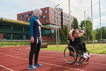 Image showing A Muslim woman in a burqa running together with a woman in a wheelchair on the marathon course, preparing for future competitions.