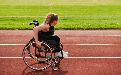 Image showing A woman with disablity driving a wheelchair on a track while preparing for the Paralympic Games