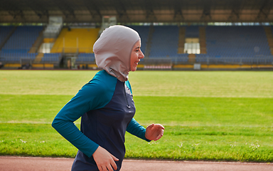 Image showing A muslim woman in a burqa sports muslim clothes running on a marathon course and preparing for upcoming competitions