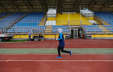 Image showing A muslim woman in a burqa sports muslim clothes running on a marathon course and preparing for upcoming competitions