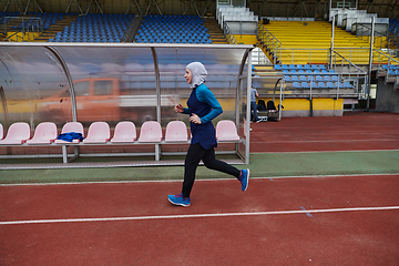 Image showing A muslim woman in a burqa sports muslim clothes running on a marathon course and preparing for upcoming competitions