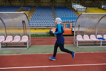 Image showing A muslim woman in a burqa sports muslim clothes running on a marathon course and preparing for upcoming competitions