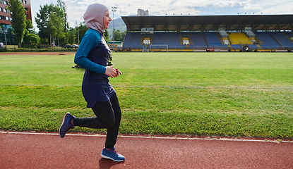 Image showing A muslim woman in a burqa sports muslim clothes running on a marathon course and preparing for upcoming competitions