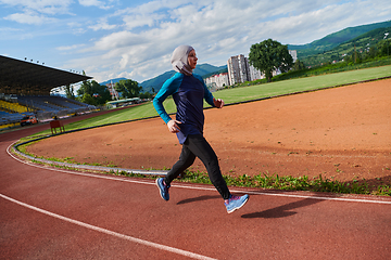 Image showing A muslim woman in a burqa sports muslim clothes running on a marathon course and preparing for upcoming competitions