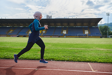 Image showing A muslim woman in a burqa sports muslim clothes running on a marathon course and preparing for upcoming competitions