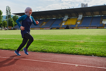 Image showing A muslim woman in a burqa sports muslim clothes running on a marathon course and preparing for upcoming competitions