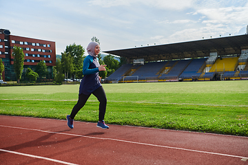 Image showing A muslim woman in a burqa sports muslim clothes running on a marathon course and preparing for upcoming competitions