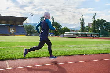 Image showing A muslim woman in a burqa sports muslim clothes running on a marathon course and preparing for upcoming competitions