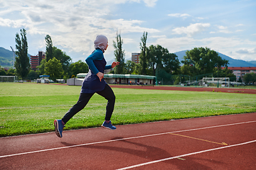 Image showing A muslim woman in a burqa sports muslim clothes running on a marathon course and preparing for upcoming competitions