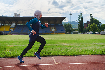 Image showing A muslim woman in a burqa sports muslim clothes running on a marathon course and preparing for upcoming competitions