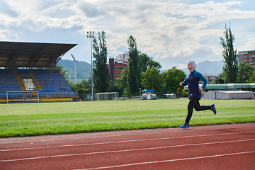 Image showing A muslim woman in a burqa sports muslim clothes running on a marathon course and preparing for upcoming competitions