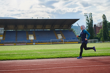 Image showing A muslim woman in a burqa sports muslim clothes running on a marathon course and preparing for upcoming competitions