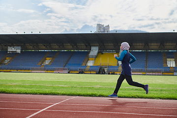 Image showing A muslim woman in a burqa sports muslim clothes running on a marathon course and preparing for upcoming competitions