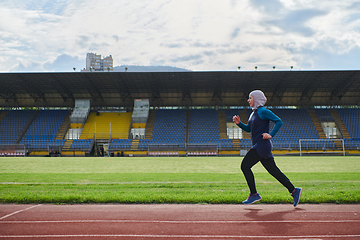 Image showing A muslim woman in a burqa sports muslim clothes running on a marathon course and preparing for upcoming competitions