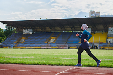 Image showing A muslim woman in a burqa sports muslim clothes running on a marathon course and preparing for upcoming competitions