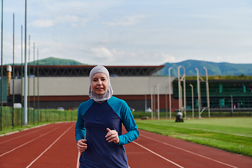 Image showing A muslim woman in a burqa sports muslim clothes running on a marathon course and preparing for upcoming competitions